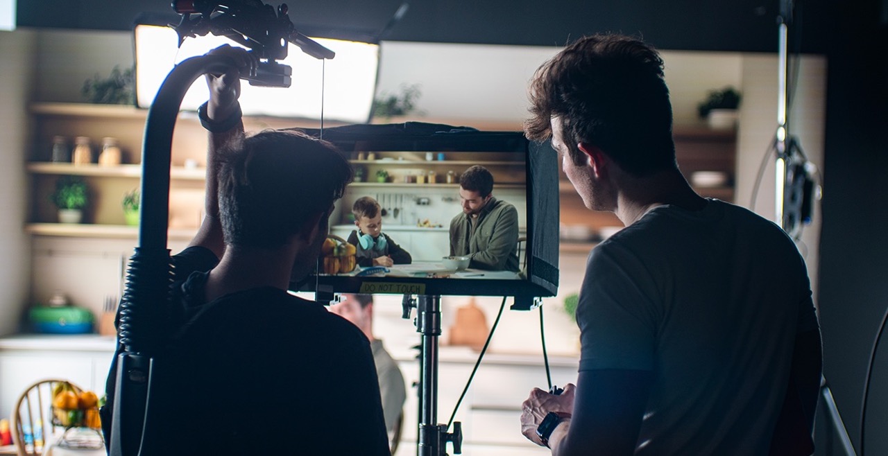 two people by a monitor on a film set